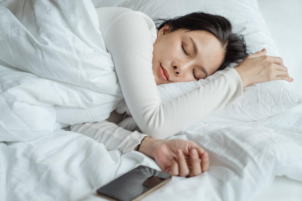 women sleeping on side in bed