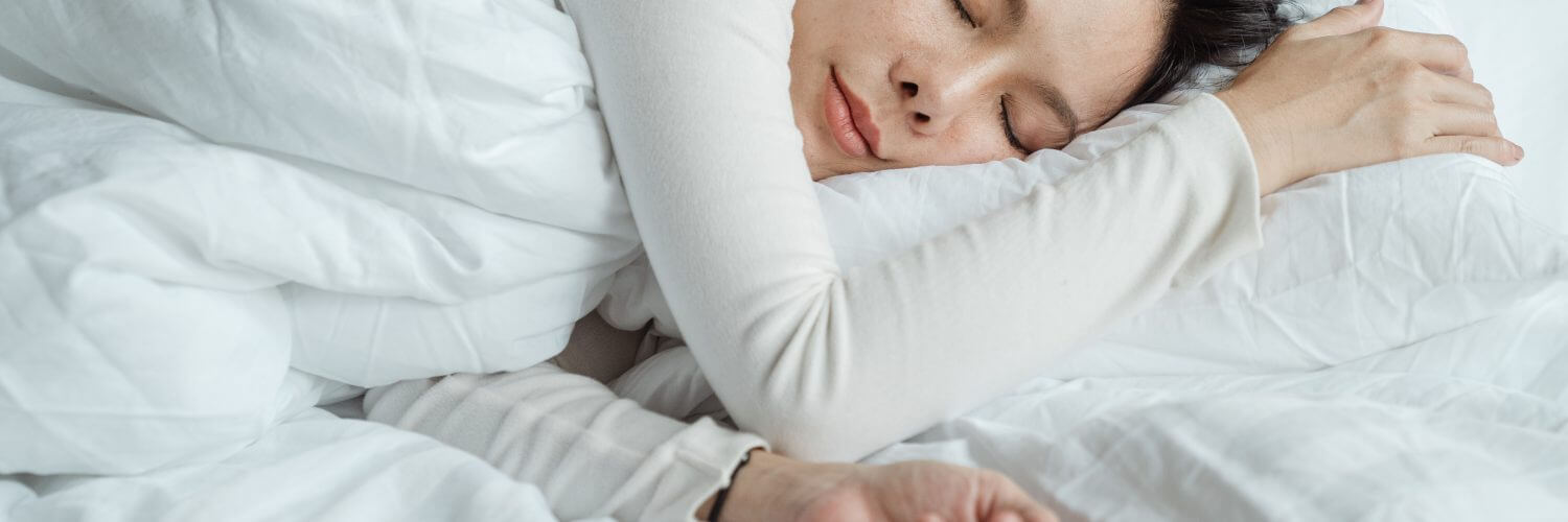 women sleeping on side in bed